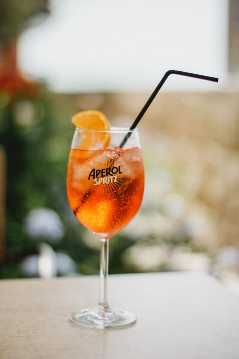 A close-up of a refreshing Aperol Spritz cocktail with ice and orange slice.