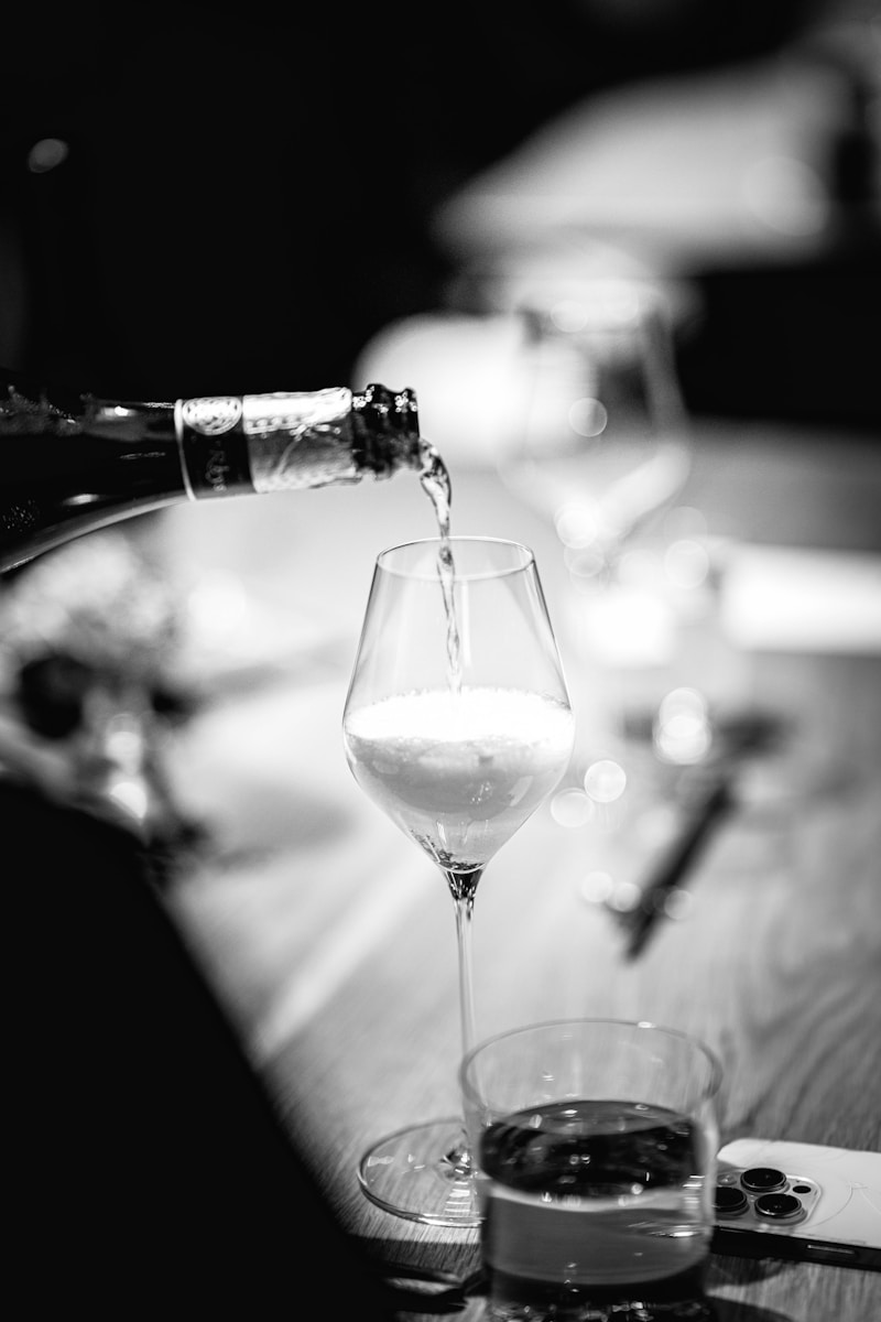 Champagne being poured into a glass at a table.